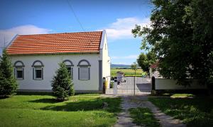 mały biały dom z pomarańczowym dachem w obiekcie Yosefsfeld w mieście Kutjevo