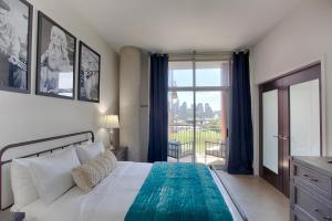 a bedroom with a bed and a large window at Mid Century Modern Downtown Condo 30+ Night Min in Nashville