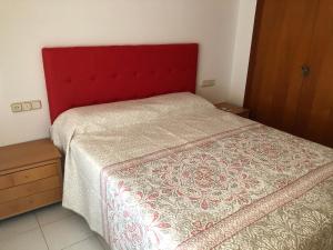 uma cama com uma cabeceira vermelha num quarto em Miraplaya em Benicàssim