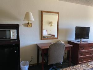 a living room with a tv and a lamp at National 9 Inn Price in Price