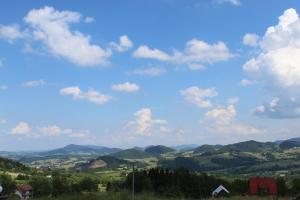 Blick auf ein Tal mit Bergen und blauem Himmel in der Unterkunft Domki Karczma Zbójnicka in Wiśniowa