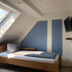 1 dormitorio con 1 cama con pared azul en Haus Hohensee, en Clausthal-Zellerfeld