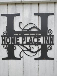 Kensington的住宿－The Home Place Inn，白色墙上的居家标志