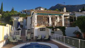 a house with a balcony and a swimming pool at Villa Tony - Benalmádena in Arroyo de la Miel