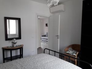 una camera con letto, specchio e sedia di "Cà di Ellen" Appartamento con deposito bici privato a Finale Ligure