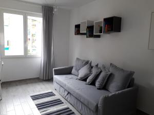 un soggiorno con divano grigio e finestra di "Cà di Ellen" Appartamento con deposito bici privato a Finale Ligure