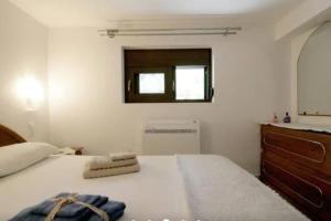 ein Schlafzimmer mit einem Bett mit einer Kommode und einem Fenster in der Unterkunft Apartment with Premium Facilities in Chania