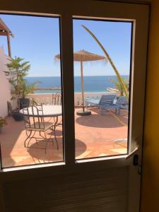 a door with a view of the beach from a patio at Villa Jardin De l'Ocean in Aourir