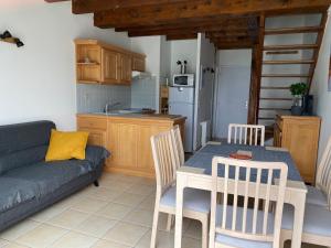 una cucina e un soggiorno con tavolo e divano di Chalet de montagne au pied des pistes station Val Louron a Val-Louron