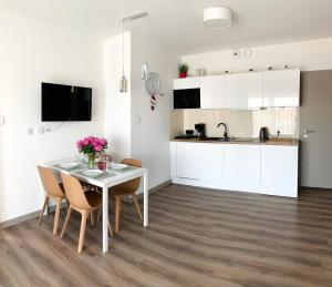 a kitchen and dining room with a white table and chairs at Apartament Livia in Sianozety