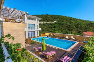 une villa avec une piscine et une montagne dans l'établissement Nikolaevskiy Guest House, à Kabardinka