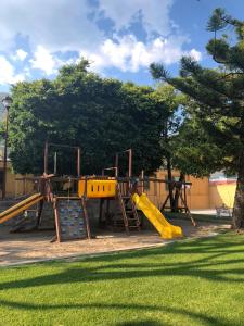 une aire de jeux avec toboggan jaune dans un parc dans l'établissement Villas Danza del Sol, à Ajijic