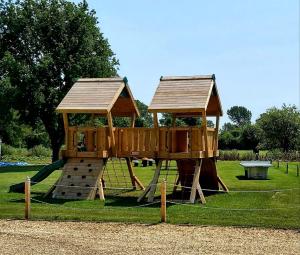 a playground with a wooden play structure in a park at The Clifden Arms B&B in Worminghall