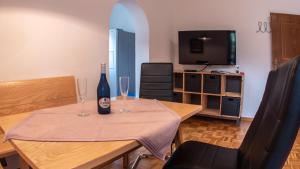 Una mesa con una botella de vino y dos copas. en Haus Christophorus, en Mayrhofen