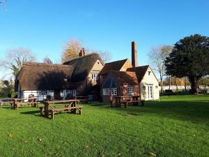 a house with picnic tables in front of it at The Clifden Arms B&B in Worminghall