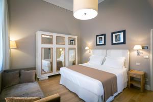 a bedroom with a large white bed and a chair at Villino Fiorentino in Florence