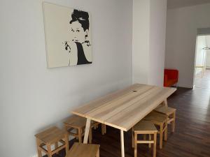 einen Holztisch in einem Zimmer mit Holzhockern in der Unterkunft 17 Bett Kapazität im Berliner Zentrum in Berlin