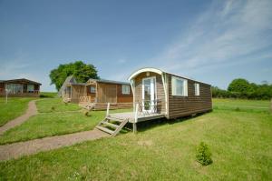 een tiny house in een yard met een veranda bij la ferme des epis in Ouffières