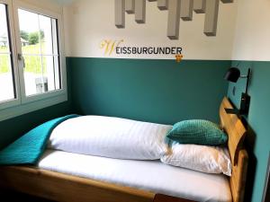 a bed in a room with a sign on the wall at Gasthof zur Bündte in Jenins