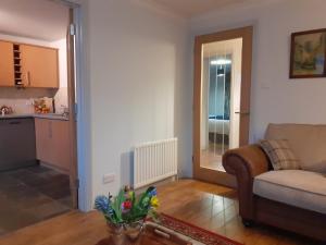 uma sala de estar com um sofá e uma cozinha em Bishops Park Apartment em Inverness