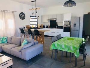 a living room with a couch and a table and a kitchen at Villa de Luxe Mon Voyage 500m de la plage in Albion