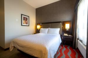 Cette chambre comprend un grand lit et une fenêtre. dans l'établissement Holiday Inn Express Hotel & Suites - Edmonton International Airport, an IHG Hotel, à Nisku