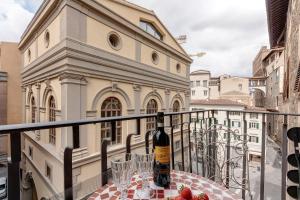 una bottiglia di vino seduta su un tavolo sul balcone di Mamo Florence - Nori Apartment a Firenze
