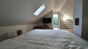 a bedroom with a large white bed with a window at Littlepanther Balaton in Balatonföldvár