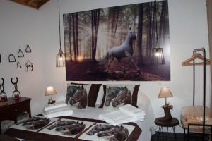 a bed with a painting of a horse on the wall at Quinta do Malhinha- Turismo in Angra do Heroísmo