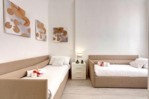 a room with two beds and a couch at Mamo Florence - Velluti Apartment in Florence