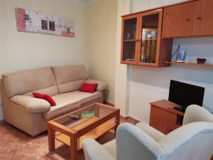 sala de estar con sofá, 2 sillas y TV en Apartamento próximo a Playa Llas, en Foz