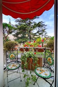 un patio con 2 sillas, sombrilla y flores en Sweet Suite V&V, en Pompeya