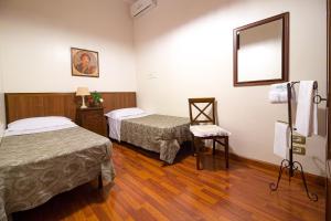 a hotel room with two beds and a mirror at Sweet Suite V&V in Pompei