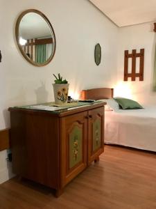 a bedroom with a bed and a table with a mirror at Hospedaria Haus Scharf in Treze Tílias