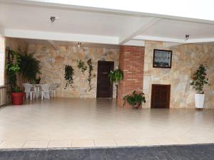 a large room with a stone wall and a flat screen tv at Hospedaria Haus Scharf in Treze Tílias