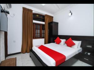 een slaapkamer met een groot bed met rode kussens bij OYO MotelVIP in Colombo