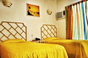 Säng eller sängar i ett rum på Sands Acapulco Hotel & Bungalows