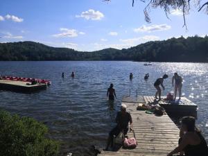 un grupo de personas en un muelle en el agua en Motel Chantolac en Sainte-Adèle