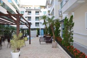 an outdoor patio with tables and chairs and plants at Apartamento Bombinhas Summer Beach in Bombinhas