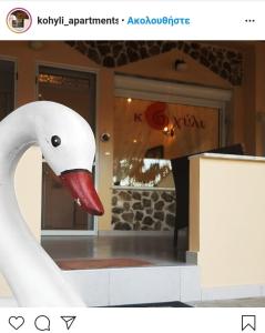 a white swan with a red beak standing on a counter at Kohyli Apartments in Skala Rachoniou