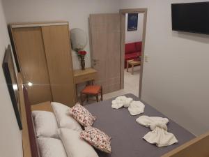 a living room with a white couch and towels at Kohyli Apartments in Skala Rachoniou