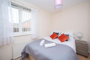 a bedroom with a bed with orange pillows and a window at Sea Winnings Apartment South Shields in South Shields