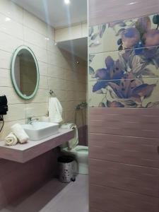 a bathroom with a sink and a toilet and a mirror at Kohyli Apartments in Skala Rachoniou +21 photos
