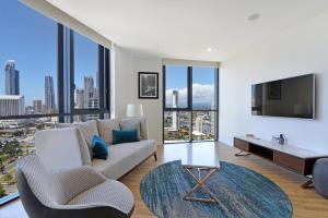 a living room with a couch and a tv at Ruby Gold Coast by CLLIX in Gold Coast