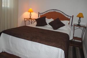 Hostal Petit Verdot في سانتا كروز: غرفة نوم بسرير كبير فيها مصباحين