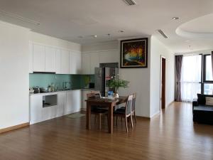 een keuken en een woonkamer met een tafel en stoelen bij Vinhomes Royal City Apartment 3 Br in Hanoi