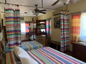 1 dormitorio con 2 camas y ventilador de techo en Hotel Casamar Suites en Puerto Escondido