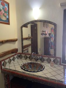 a bathroom with a sink in front of a mirror at Hotel Casamar Suites in Puerto Escondido