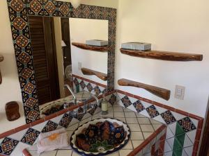 een badkamer met een wastafel en een spiegel bij Hotel Casamar Suites in Puerto Escondido