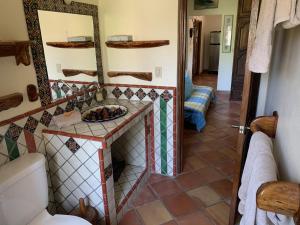 baño con lavabo y suelo de baldosa. en Hotel Casamar Suites en Puerto Escondido